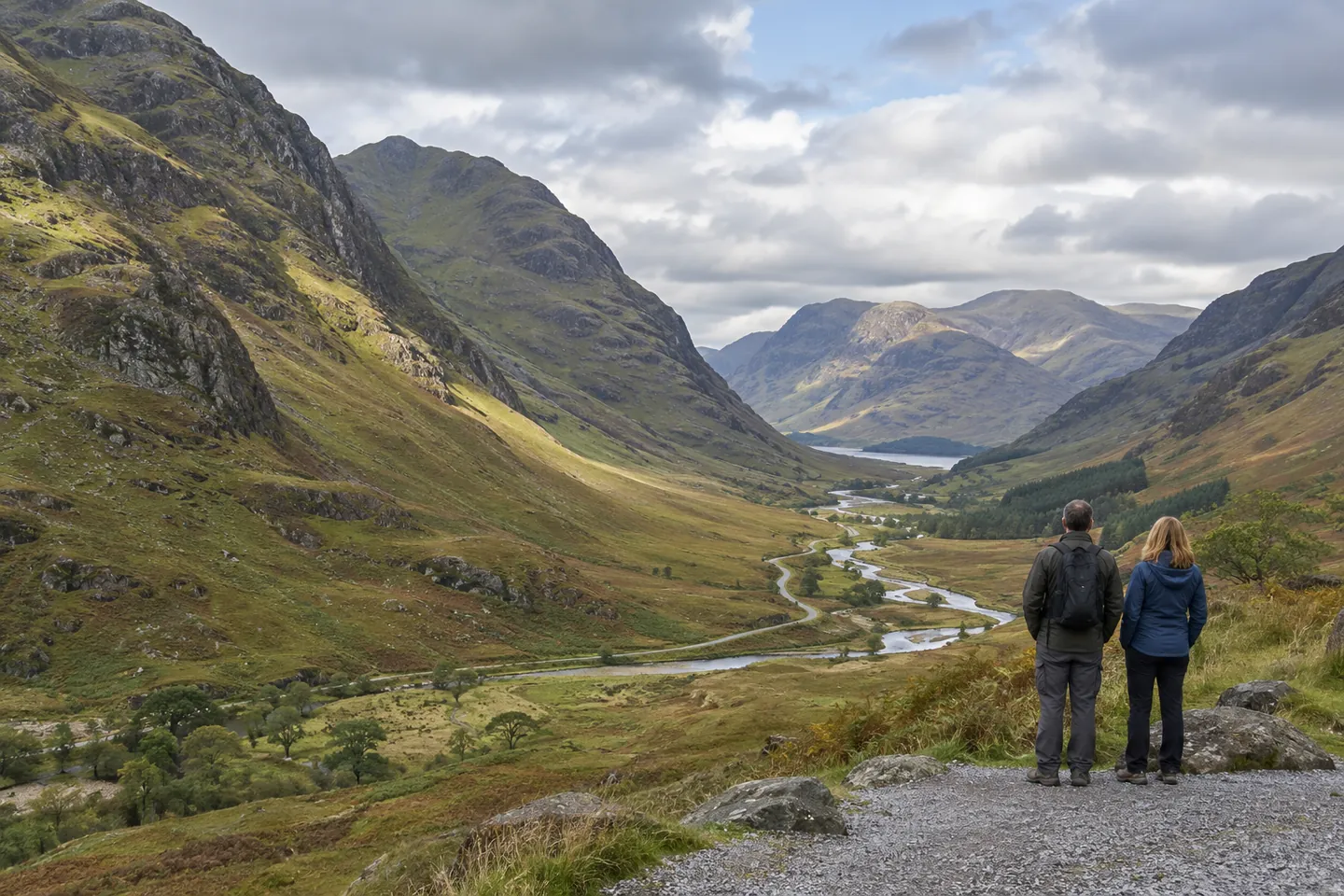Dos viajeros contemplan un valle de las Highlands desde un mirador