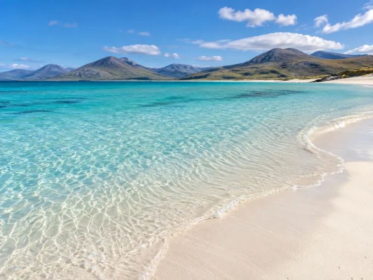 Playa de arena blanca y aguas turquesas con montañas en Harris